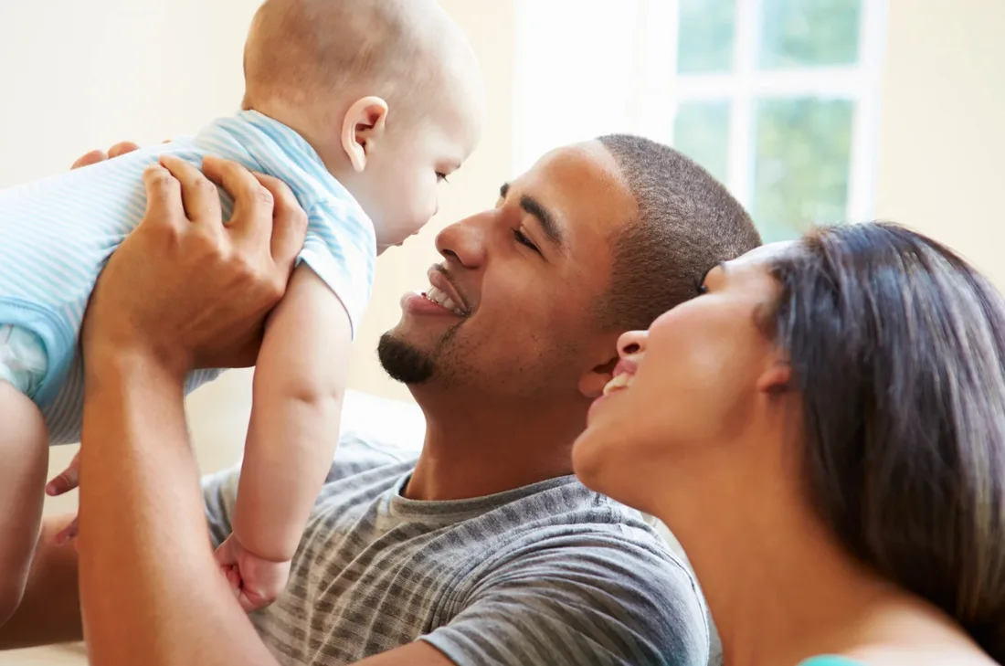 A Bronx family sharing a tender moment with their baby, reflecting the community Benjamin's Pharmacy serves