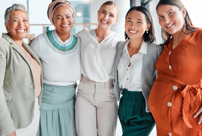 A group of five diverse women of different ages smiling together